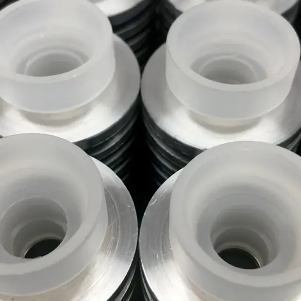 Piezas blancas de plástico con forma de copa sobre discos metálicos apilados